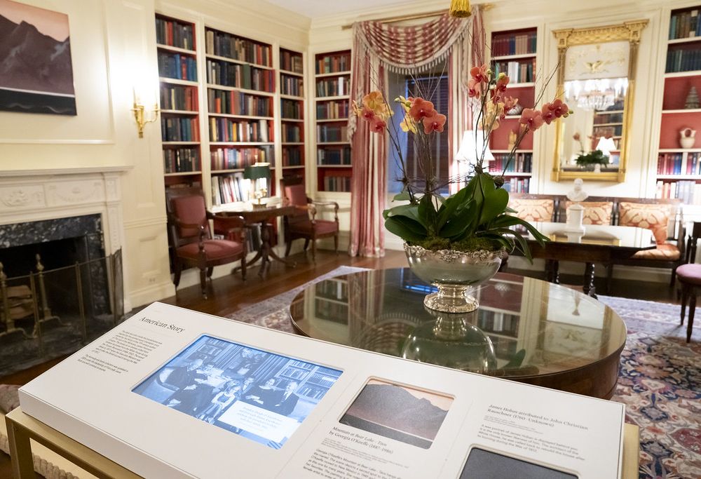 Interpretive stand with a video screen and text in front of a room in the White House