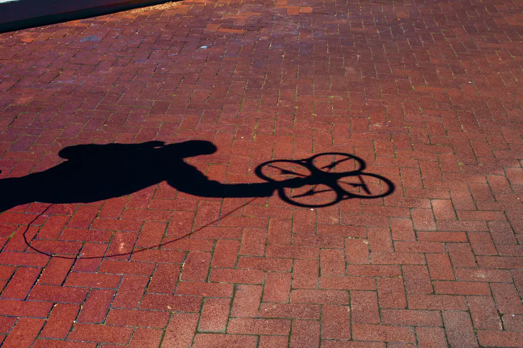 opener: shadow of quadcopter against brick floor