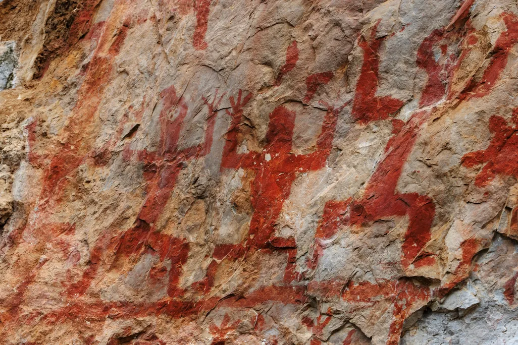 Close-up view of red figures painted onto a rock