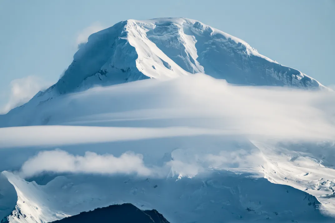 Mount Iliamna, a stratovolcano in the Aleutian Range, shows itself after a day of cloud cover.