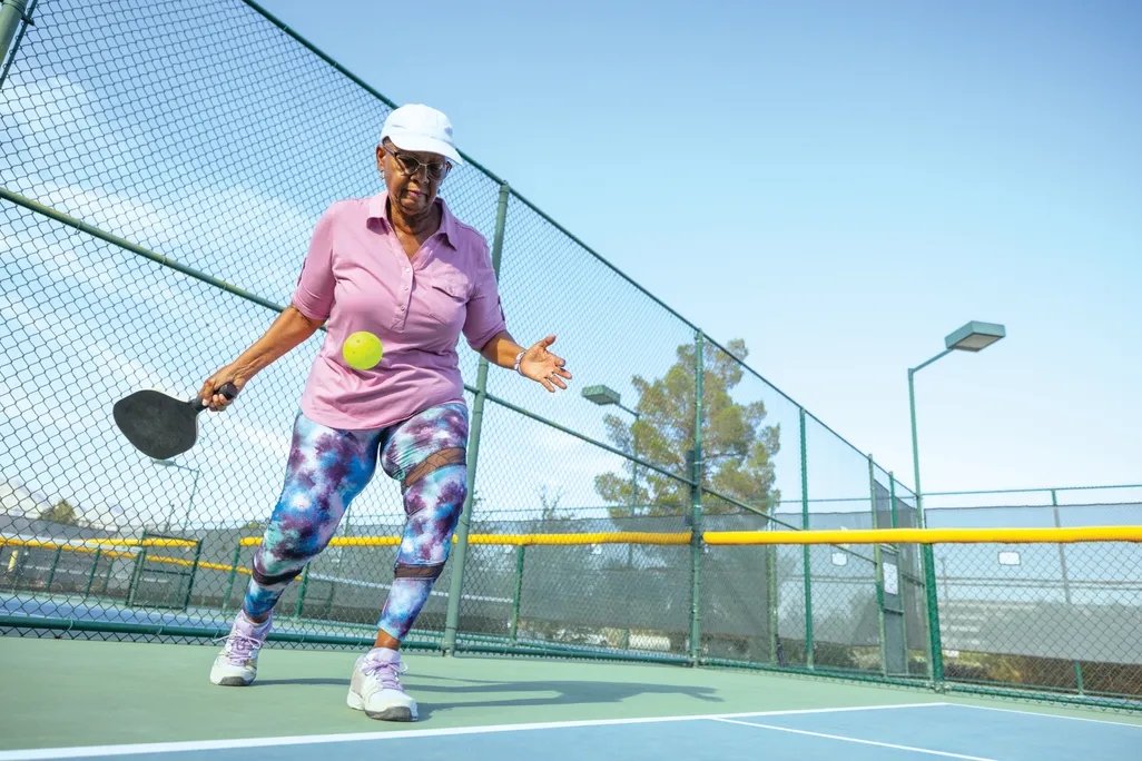 a woman returning a ball in pickleball