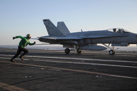 Even an Olympic sprinter couldn’t beat an F/A-18C Hornet. But as this aircraft touches down on the Nimitz, Boatswain’s Mate Vanzel Simmon, a hook runner, bolts alongside and then straight for the tail, ready to manually pull the hook off the arresting wire if it does not disengage on its own. 