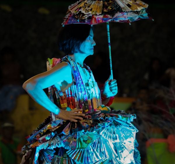 An “Eco Modelo” pageant contestant presenting a waste-paper costume thumbnail