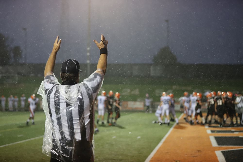 a referee raises his arms to signal a touchdown