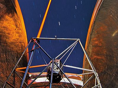 A laser shoots from the Keck observatory dome to act as a guide star.
