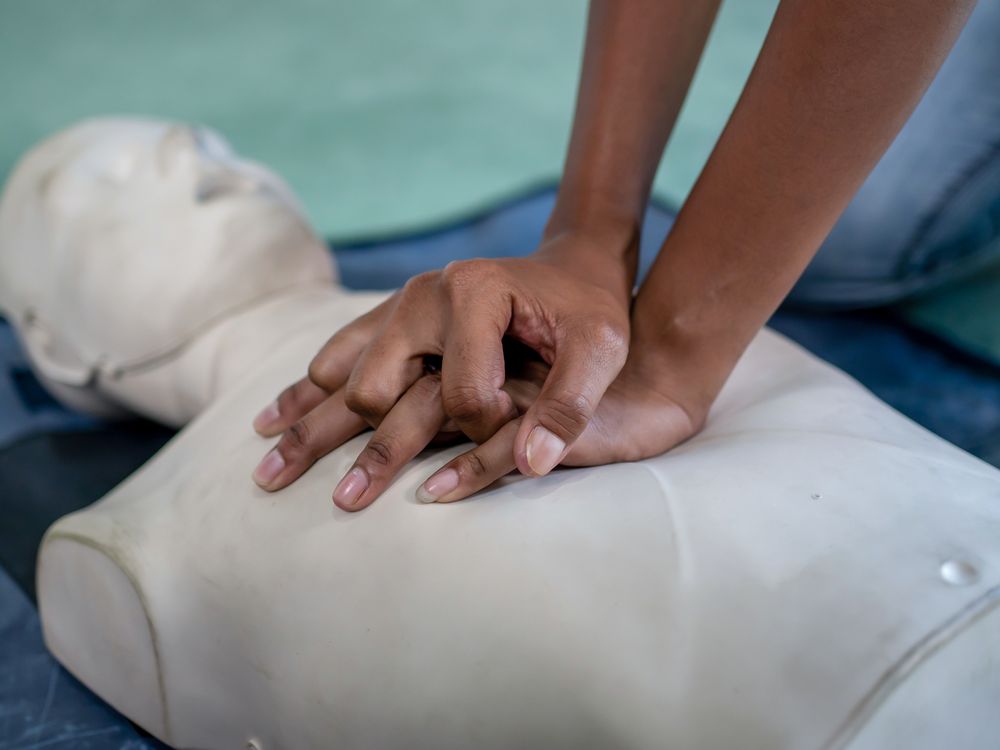 A person performs CPR on a dummy