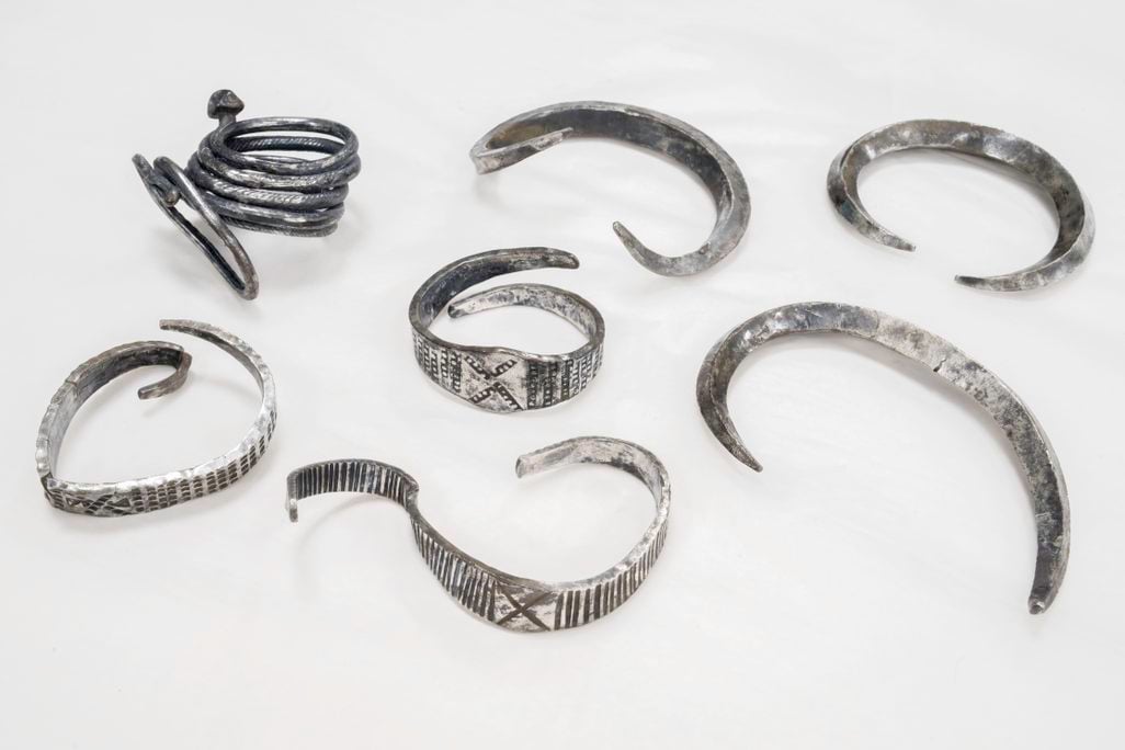 Seven silver bands on a white surface