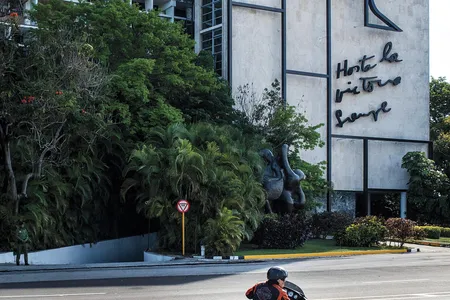 Ernesto Guevara cruises by an image of his father on a building in Havana's Plaza of the Revolution, one of the larges public squares in the world.