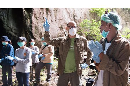 Dr. Kevin Olival and the USAID PREDICT wildlife team surveying areas for bat trapping at the entrance to a cave in Thailand.
