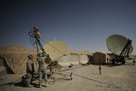 Satellite communications technicians conduct routine maintenance on a satellite dish at Kandahar Airfield in Afghanistan. 