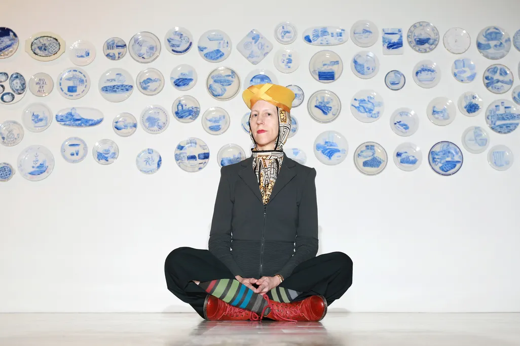 Artist Julie Green poses in front of a selection of The Last Supper plates in 2015.