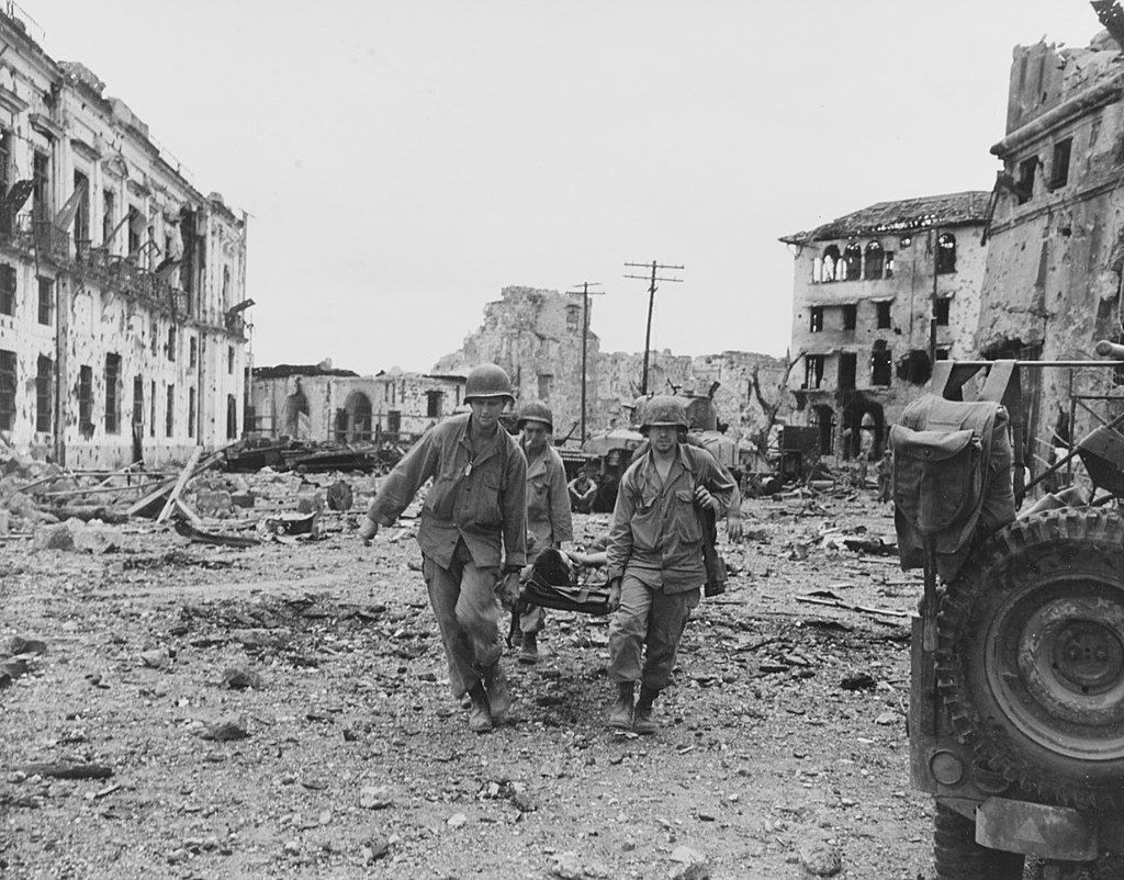 American soldiers carrying a wounded comrade through the ruins of Intramuros during the Battle of Manila
