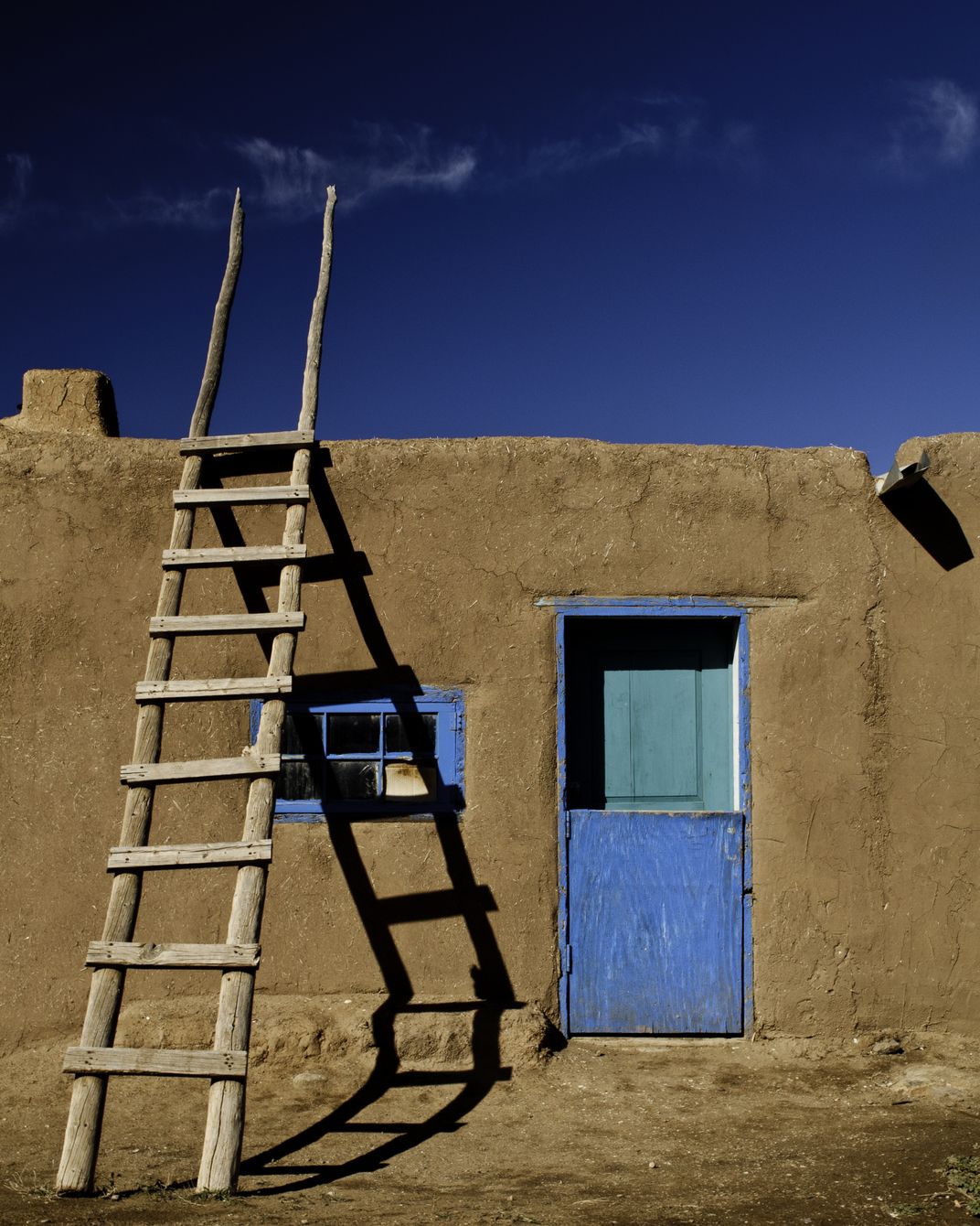 a ladder leans on a clay house