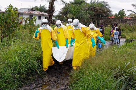 Liberian nurses carry a dead body suspected of dying from the Ebola virus at the Roberts field highway on the outskirts of Monrovia, Liberia, 25 September 2014.