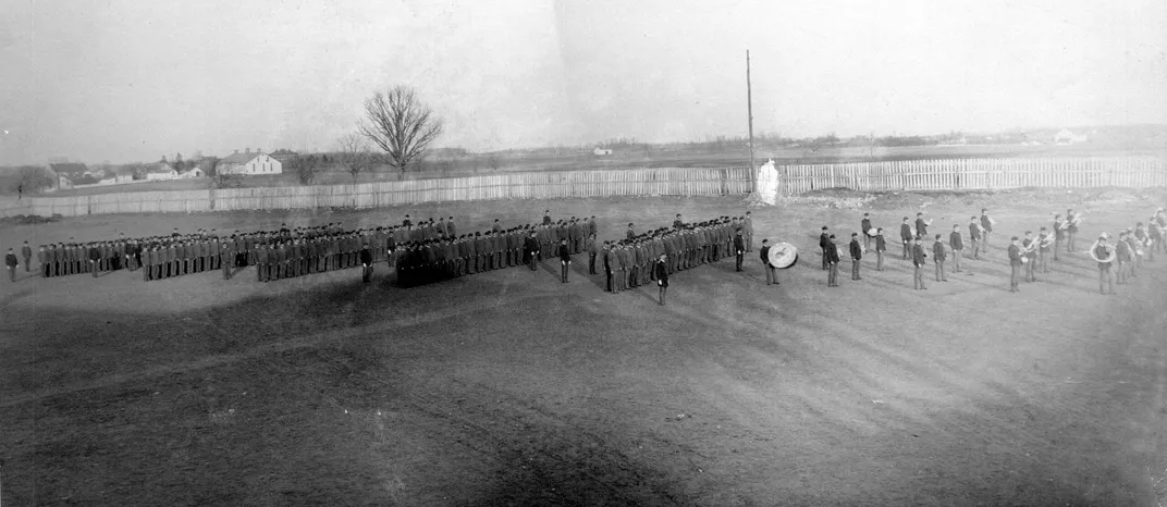 Dress parade of Native youth in military uniforms on the grounds of the Carlisle Industrial School in Carlisle, Pennsylvania.