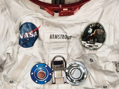 Armstrong’s pressurized spacesuit, measuring nearly 5 feet 7 inches tall, featured anodized aluminum gauges and valves. (Detail)