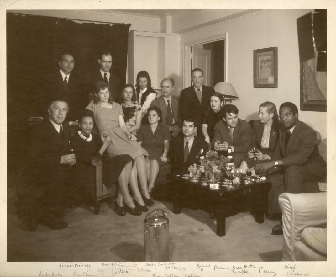 Duchamp with a large group of people in a sitting room