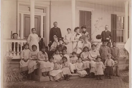 Richard Henry Pratt, founder of the Carlisle Indian Industrial School, poses alongside students around 1900.