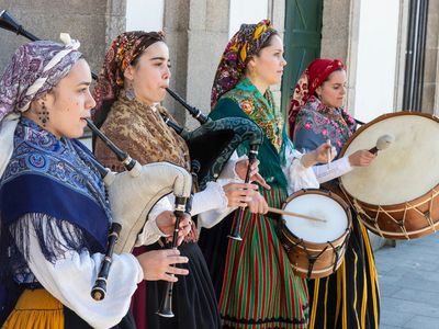 Via Getty: "A group of young women in traditional costumes play Galician music with bagpipes, tambourines and drum in the historic center during the San Froilan festivities on October 6, 2019 in Lugo, Galicia, Spain." 