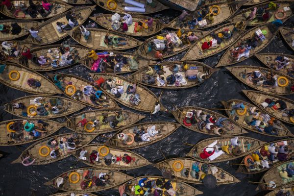 Boats filled with travelers crossing the river to their workplace thumbnail