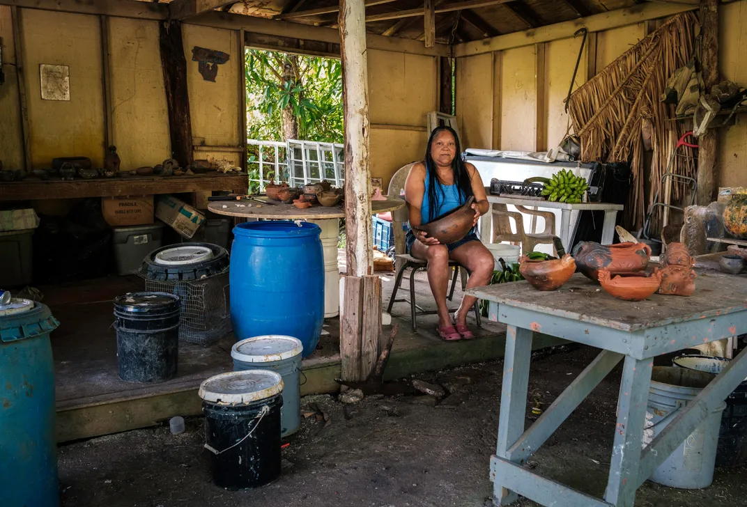 a women sits for a portrait in her pottery workshop