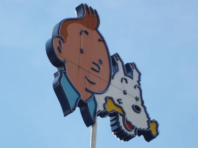 Boy reporter Tintin and his dog Snowy portrayed in a sign. Although Tintin's later adventures are fairly innocent, the comic has dark roots.