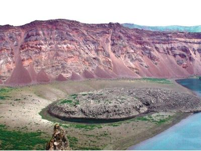 The eruption at Zavaritskii volcano created a nearly two-mile-wide caldera with layers of red, black and white from previous eruptive deposits.