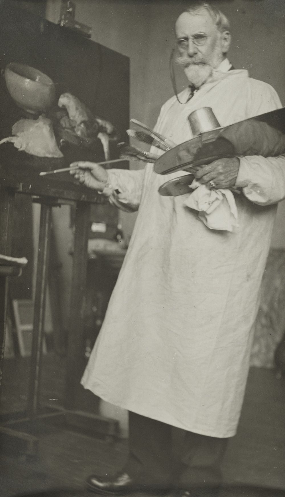 Photograph of William Merritt Chase painting in his studio.