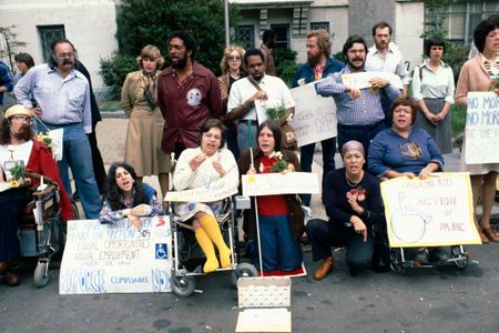 A group of activists, including Judy Heumann (center, with yellow stockings) protest for the enforcement of Section 504 of the 1973 Rehabilitation Act, in April of 1977. Later that month, the protesters would occupy a federal building in San Fransisco in protest in a sit-in that lasted more than 25 days. 