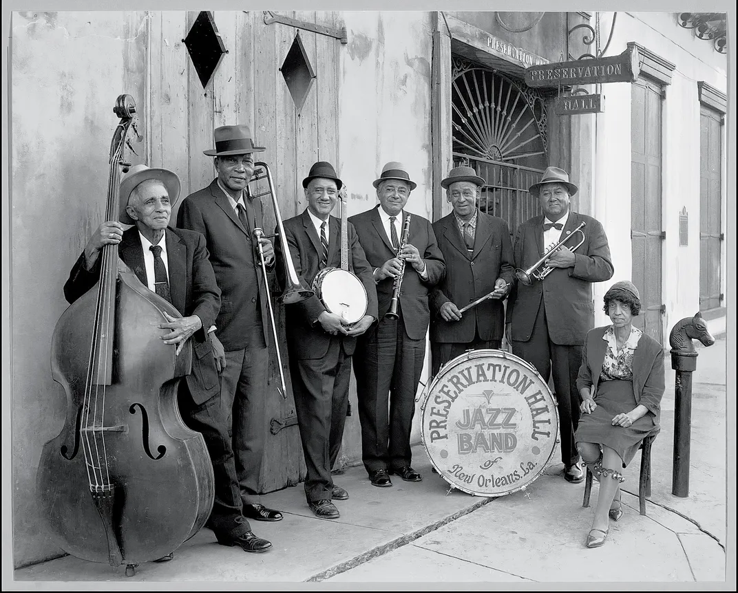 a black and white photograph of a band standing outside a building in New Orleans