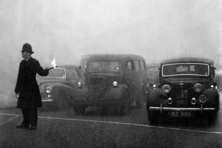 A policeman uses flares to guide traffic during the Great Smog of 1952.