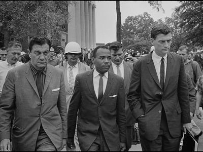 James Meredith, center, is escorted by federal marshals on his first day of class at the University of Mississippi.