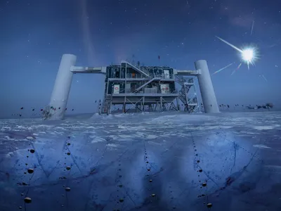 The IceCube Neutrino Observatory at the South Pole sits atop under-ice detectors (artist impression) that catch the blue glow created by a cosmic neutrino.