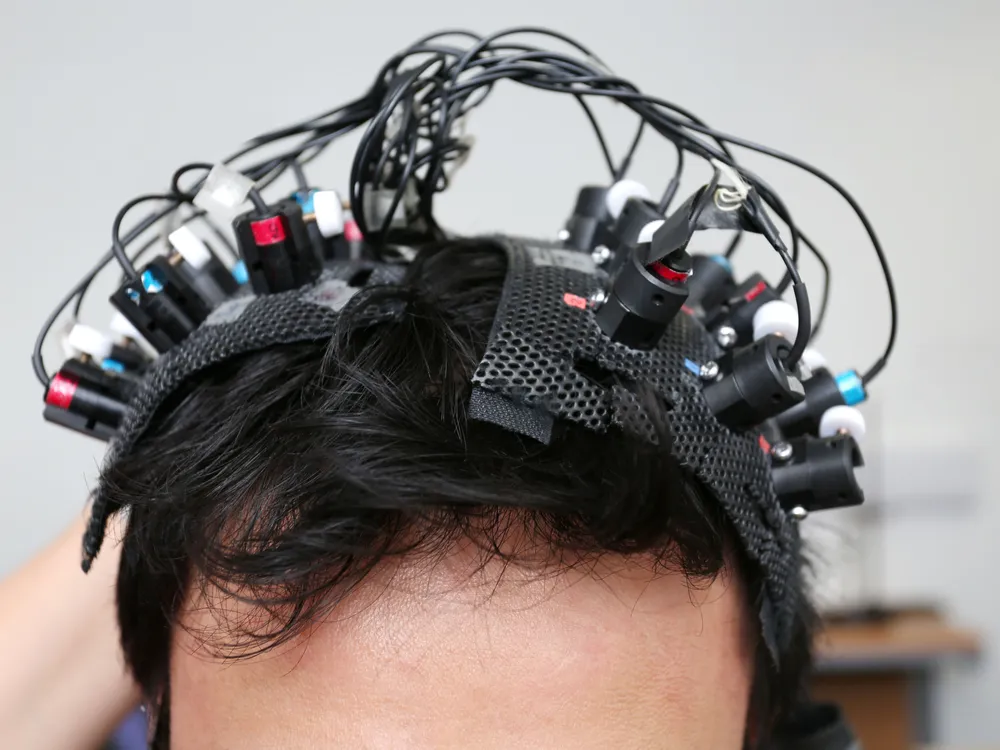 La testa di un uomo con molti fili ed elettrodi attaccati al cuoio capelluto