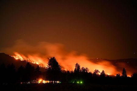 In this long exposure picture, trees burn on a hillside behind Honey Lake campground during the Dixie Fire on August 18, 2021 in Milford, California. The wildfire in Northern California continues to grow, burning over 626,000 acres according to CalFire. 