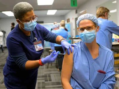 An RN administers the Covid-19 vaccine to a nurse at the Virginia Hospital Center in Arlington, Virginia.  