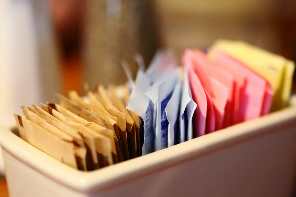 A close-up of sweetener packets in a container
