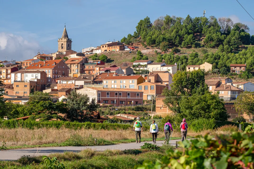 Hikers walk toward the village of Navarrete in Spain's Rioja wine country