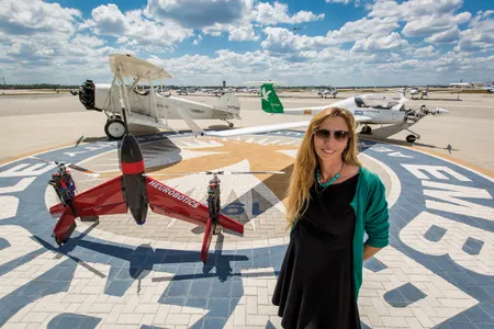 Embry-Riddle professor Carolina Anderson with three generations of aircraft on campus. The daughter of a pilot, she flies her own daughters to work with her, hoping to nurture a third flying generation in her own family.