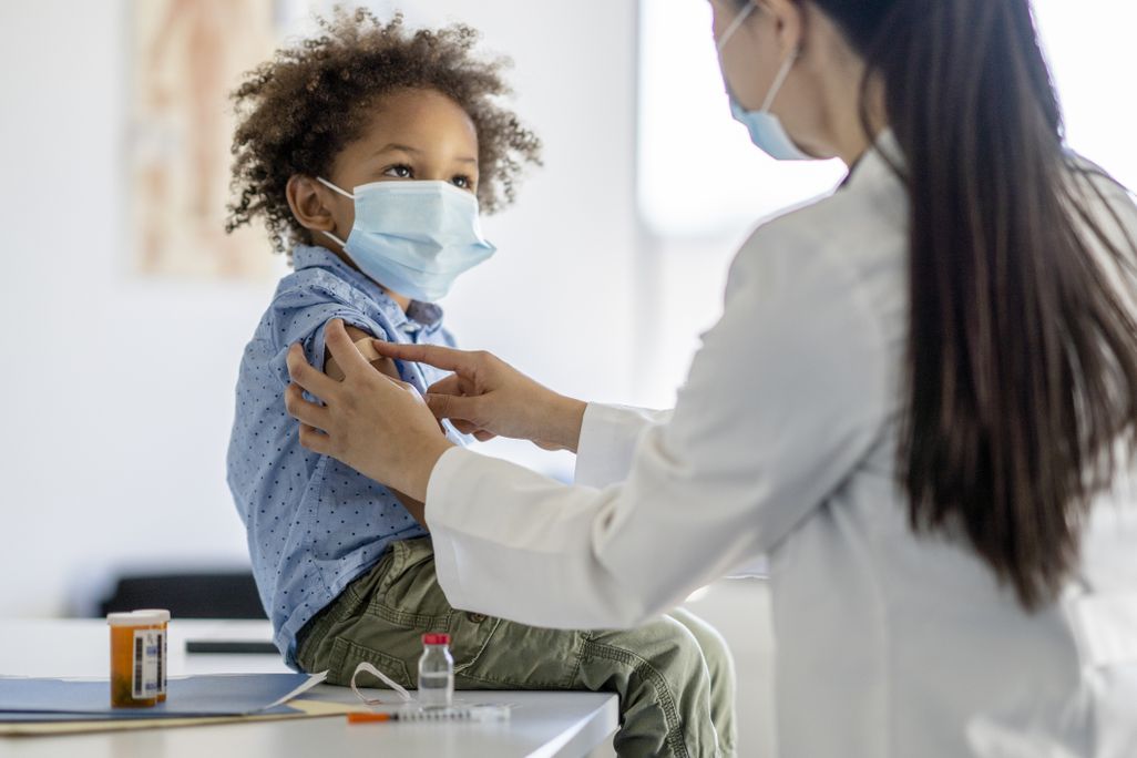 A nurse puts a band-aid on a child after he received a shot