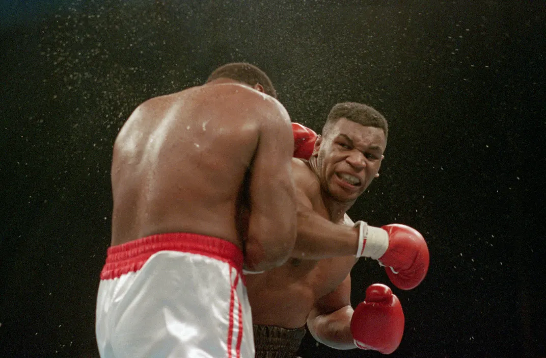 Tyson lands a knockout punch to the jaw of challenger Larry Holmes during the fourth round of the World Heavyweight Championship in January 1988.