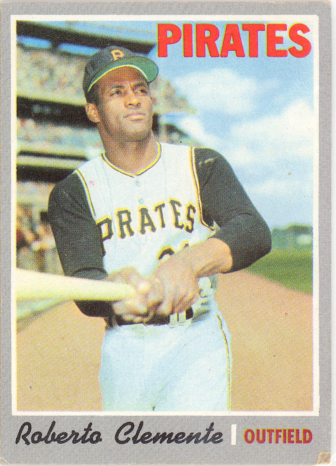 Sports card featuring baseball player Roberto Clemente wearing his Pirates team uniform, holding a baseball bat, and standing in a baseball field.