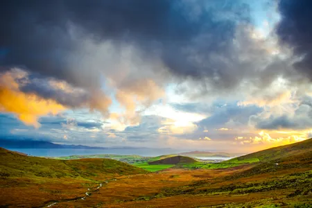 Greens, yellows, blues, browns and more warm hues merge to paint a colorful landscape of pastures in Ireland.
