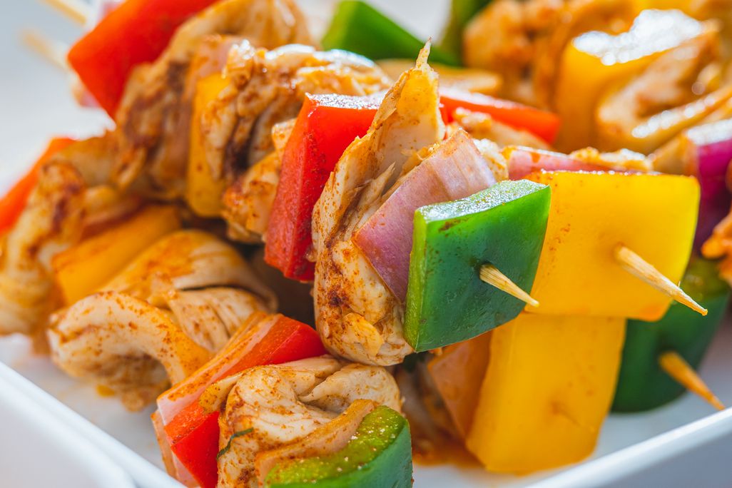 skewers with lab-grown chicken, peppers and onions on a plate