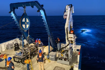 The Nautilus, a research vessel operated by the Ocean Exploration Trust, and the ROV Hercules (in the water) on the hunt for a cancer-busting marine bacteria.