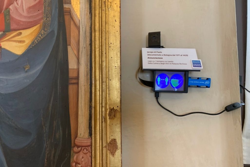 A small blue screen sits next to a gilded frame 