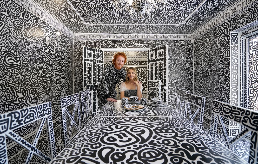 Sam Cox and his wife, Alena, in their entirely doodled mansion.