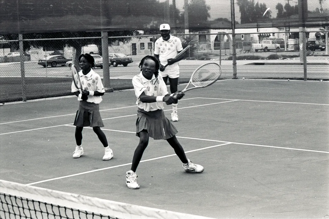Venus (right), Serena (left) and their father Richard (back) on the court in 1991