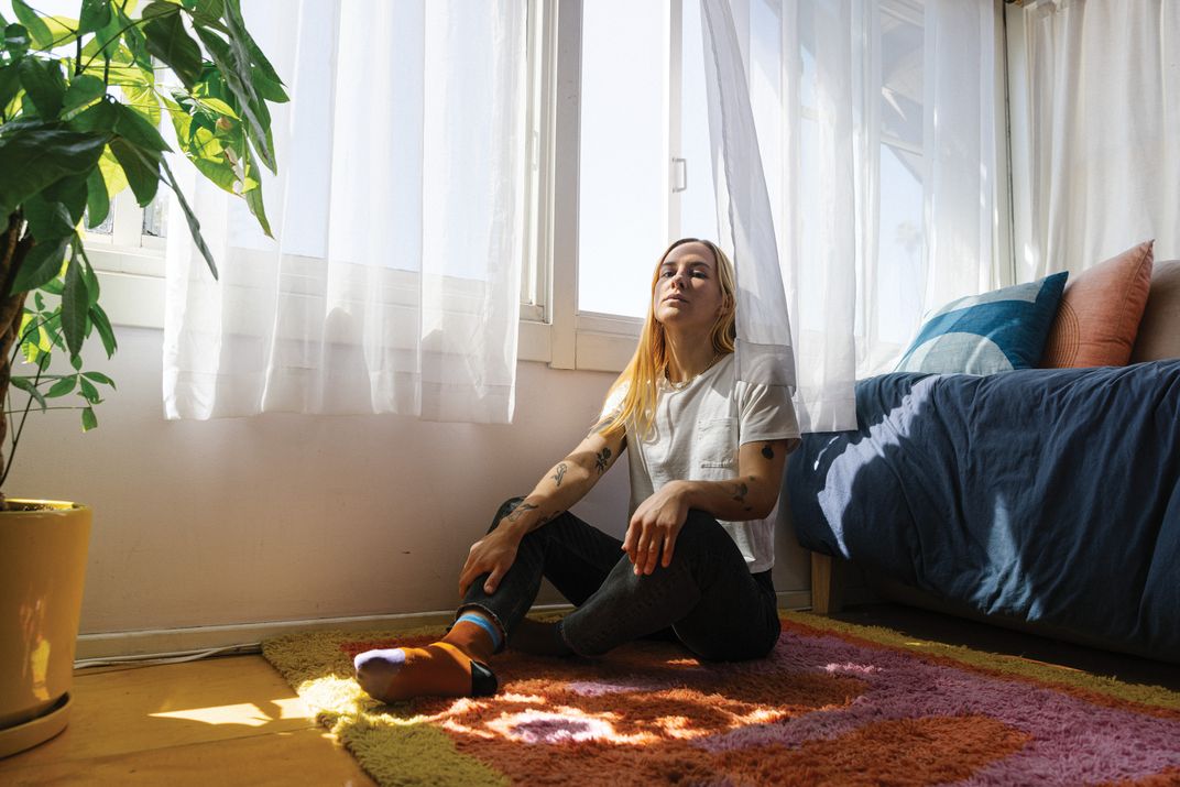 a women sits on their living room floor