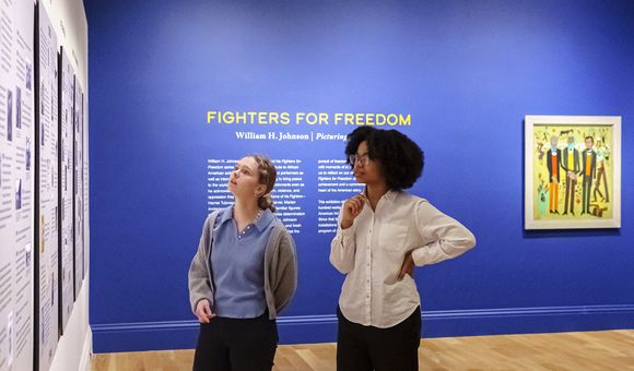 Visitors look at a timeline of William H. Johnson's life
